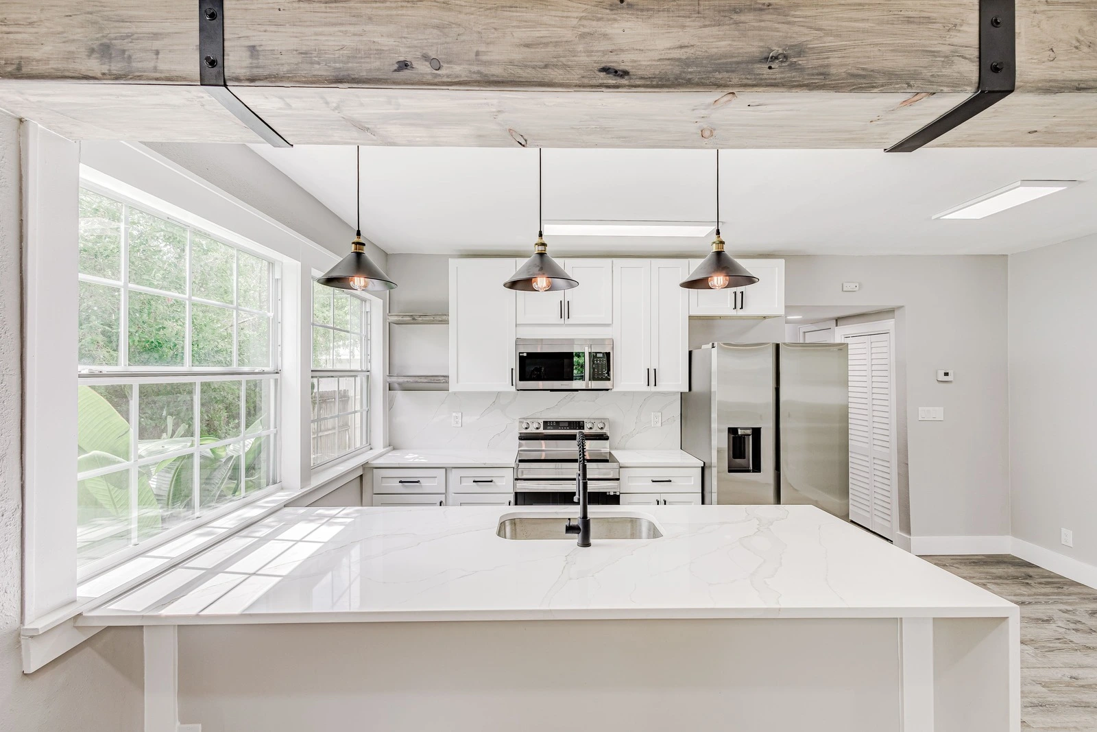 Finished Tampa Kitchen Remodel With White Shaker Cabinets, Quartz Counters, Pendant Lighting Over The Island